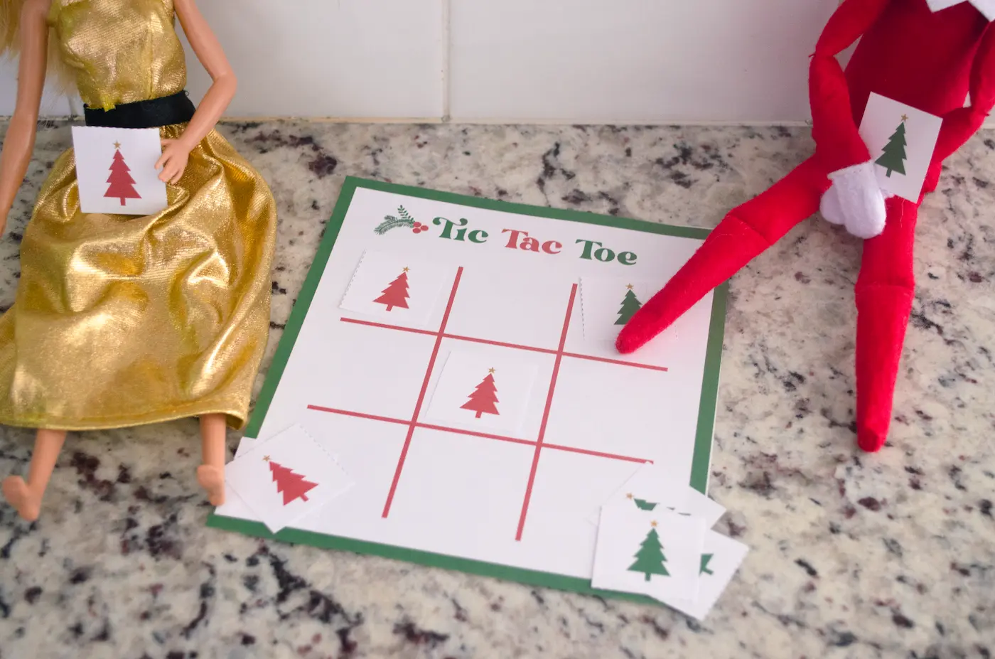 Elf and barbie playing elf on the shelf tic tac toe.